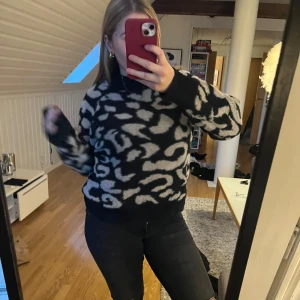 Svart och vit leopardmönstrad tröja - Säljer en svart och vit leopardmönstrad tröja med hög krage. Tröjan har långa ärmar och en mysig passform, perfekt för kyligare dagar. Den är både stilren och trendig, vilket gör den till ett måste i garderoben.
