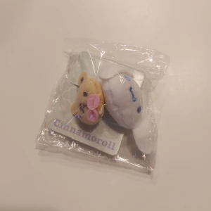 Cinnamoroll hårsnodd från Sanrio - Söt Cinnamoroll hårsnodd från Sanrio med en vit och blå design. Den har en liten beige figur med rosa detaljer. Perfekt för en söt look. Skriv om ni har någon fundering!✨️
