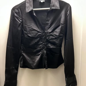 Svart skjorta  - Svart silkes skjorta i storlek S/36. Använd fåtal gånger och är i väldigt bra skick. Sitter super snyggt och tajt 