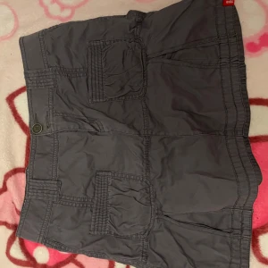 Grå kjol från 2000talet - Säljer en grå kjol från edc med flera praktiska fickor och knappstängning. Min syrra den på 2000talet💕. Inget fel på dem. Passar nog lite minde storlek än vad det står💕 