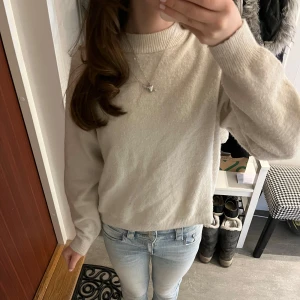 Vit tröja från H&M - Säljer en stilren kräm vit stickad tröja från H&M i storlek XS. Tröjan har en klassisk rund halsringning och långa ärmar. Endast använd några få gånger och är i mycket bra skick! Tröjan är verkligen sååå skön men säljer då jag tyvärr inte använder den.