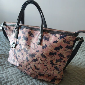 Väska från Radley - En söt väska från brittiska märket Radley. I vaxat tyg och ställbar axelrem och två korta handtag. Litet fack med dragkedja inuti. Inköpt i London för några år sedan. Använd men fortfarande i bra skick.