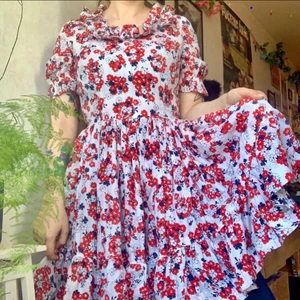 Handsydd äkta vintage klänning  - Sagolik unik hemsydd vintageklänning med blåa och röda blommor mot en vit bakgrund. Kjolen är dramatiskt och snurrar jättefint verkligen en sommarklänning rakt ur 50-talet 