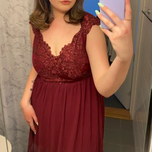 Balklänning vinröd - Balklänning använd endast en gång, spetsdetaljer på både framsidan & ryggen. Ganska stor i storleken. Långklänning 