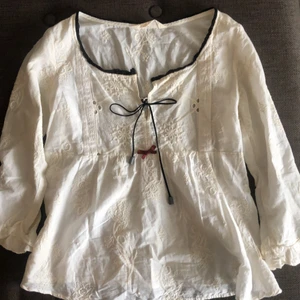 Söt blus Odd Molly stl 0 - Söt och romantisk blus från Odd Molly. Broderad spets, volang i ärmslut, fin snörning i halslinning, 3/4 ärm, benvit stl 0 (XS)
