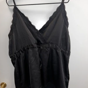 Svart spets topp - Svart spets topp som man kan spänna i midjan. 