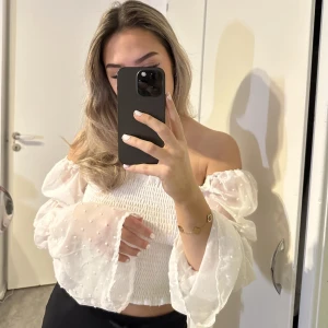 Vit topp med volang ärmar - Superfin vit långärmad topp med volang ärmar.  Bra skick, använd 2/3 gånger!  Kan användas på 2 sett (se bilder) 