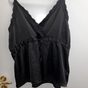 Svart linne - Svart linne med spets som går att spänna i midjan. 