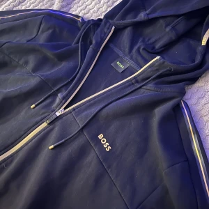 Hugo boss hoodie - Hugo boss hoodie i bra skick För stor för mig men skulle passa en Xl eller mindre och större beroende på hur man vill att den sitter.  Väldigt oversized på mig som är M🤍 Säljs billigt då jag vill bli av med den så kom med egna prisförslag 