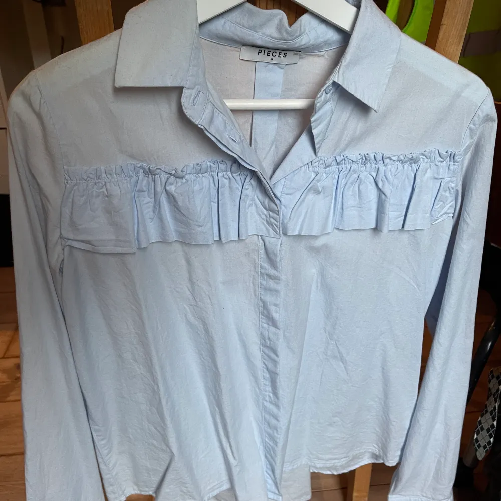 Ljusblå skjorta med volang på bröstet 💙 . Skjortor.