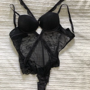 Svart spets body rhinestones - Super snygg helt ny oanvänd spetsbody i svart med rhinstones och fina detaljer. Går även att ta bort spetsbanden vid halsen. Strlk XS/S Push up kupa i 75A men passar även en B kupa. Har en fin öppen rygg. Har tyvärr inga bilder på. 