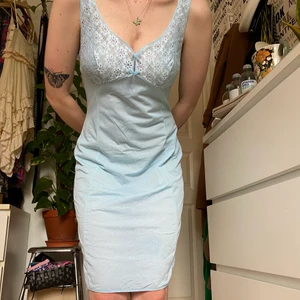 Ljusblå underklänning med spets  - Gullig ljusblå underklänning med spets över bysten samt rosetter. Ingen etikett eller storleksmarkör men skulle säga stl M.   Du som köper står för frakt, möts annars upp vid Stockholm City. 