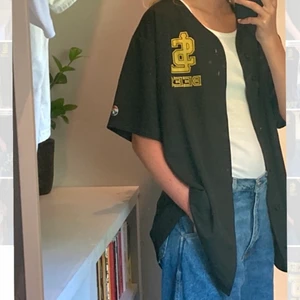Baseball tröja - Mitt första second hand fynd! Oversized svart baseball tröja men gult tryck på framsidan och på ryggen. Skulle uppskatta att det är storlek L/XL. Väldigt bra skick, 100% polyester.