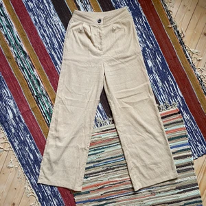 Beige högmidjade byxor  - Ett par snygga högmidjade Manchester likande byxor i beige färg. I fint skick. För fler bilder eller mått kontakta mig :) Frakt sker via PostNord spårbart 57 kr 📦