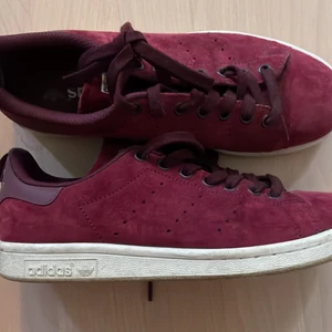 Adidas Stan Smith sneakers i mocka - Sneakers från Adidas i vinröd mocka. Modellen Stan Smith (tror jag).  Storlek 39 1/3 - skulle dock säga att de är små i storleken. Passar 38/39.  Använda men fint skick 👍🏼