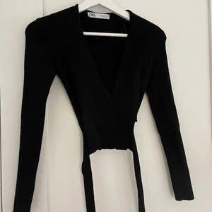 Svart zara topp svart - Plagget är köpt för 2 år sedan, banden knyts runt midjan och tröjan har en fin V ringning.