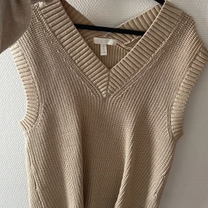 Stickad tröja  - Stickad ärmlös tröja, fint skick! Aldrig använd, endast testad.