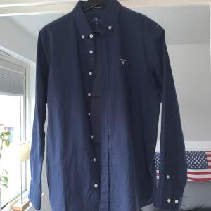 Marinblå Gant skjorta som knappt är använd, skicket är 10/10! Storleken är 170 och sitter som XS. Nypris: 650kr