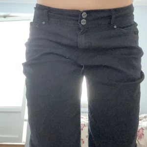 Svarta jeans - Svarta mid/low rise jeans med bootcut. innerbens längder är 76cm och midjemått ( mätt rakt över) 38cm