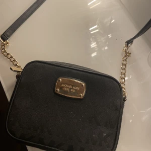 Väska - Jag säljer min lilla Michael kors väska med guld detaljer. Väskan är använd fåtal gånger då jag inte riktigt gillar storleken.