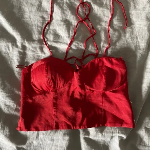 Röd topp - En röd topp i satin-liknande material med snörning där bak