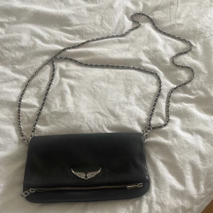 Zadig & Voltaire väska - Säljer min Zadig & Voltaire väska då jag inte använder den längre. Färgen på silverdetaljerna har gått bort lite, men annars väldigt fin. Köpt för 3265 säljer för 2000. Kan gå ner i pris vid snabb affär.