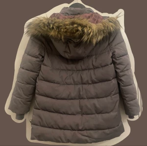 Barnjacka  - Barnjacka i stl 128! Jackan har använts och har defekter som slitningar och lösa trådar. Skriv vid närmare bilde på detta! 