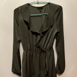 Fin volangklänking! - Jättefin volang klänning i omlott! Resår i midjan som framhäver figuren! I khakigrön satin!