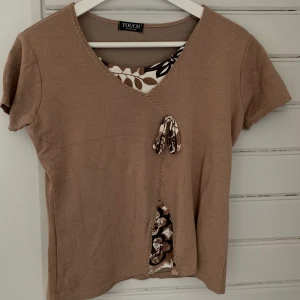 Brun topp - Brun vintage topp som är väldigt detaljrik vilket gör den unik🤍🤎 Står Ingen storlek men passar S/M☺️