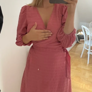 Fin klänning / Wrapklänning / Balklänning i Dämpad rosa - Säljer min fina rosa wrap-klänning från Ichi. Storlek 36 men passar alla möjliga storlekar då den går att justera med bandet. Haft den en gång på bal! Även väldigt avslappnad om man vill ha den till vardags / på semester. Nypris 900 kr.