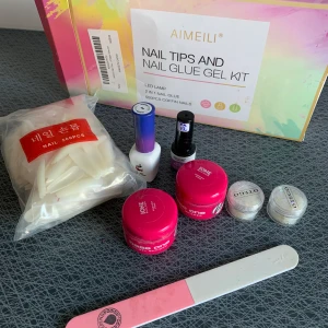 Nakelkit gele  - Ingår Naglar Vit och lila färg 2 burkar gelé byggbar  2 burkar glitter 1 uv lampa 1 top coat 1 nagelfil 1 nagellim  Använt 1 gång!!!!