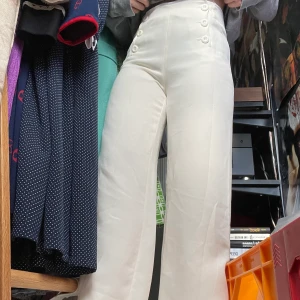Byxor från côté femme  - Fina creme/vita vida byxor med knappar, dom är köpta second hand men i bra skick. Katt i hemmet. Köparen står för frakten. 