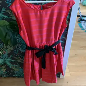 En röd klänning med rosa ränder och ett band man kan knyta runt midjan✨. Pernilla Wahlgrens egna märke!  200kr + frakt ( 39kr )🌸💗