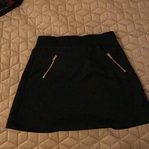 Svart kort kjol - En svart kjol som jag haft i ungefär 2-3 år inte så mycket använd fickorna är inte äkta man kan öppna men inte lägga något i fickorna