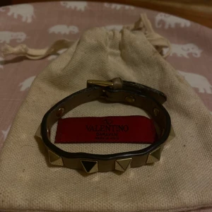 Valentino armband - INTE prutbart🧡 Äkta Valentino armband i beige! Säljer det i befintligt skick då jag använt det en hel del. Lite nött samt så har jag vid ett tillfälle limmat ihop ena änden (se bild 2) vilket även gjort det lite ”segt” att stänga. Dustbag+armband följer🧸 