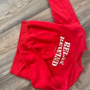 Röd Hoodie strl S - Jg har bara använt denna Hoodie en gång innan, köpt på H&M. Text: relax rewind  easy soul atheletics. Hoodien har ribbade kanter på armarna, längst ner och på huvud hålet. Vi kan hitta ett pris som passar bpda oss! ORGINAL PRIS: 250kr