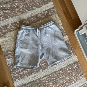 Lacoste shorts M - Gråa Lacoste mjukisshorts i storlek M. Bra skick trots flitigt använda