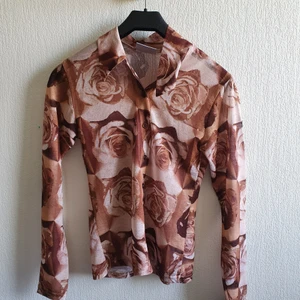 Mesh topp i grafiskt mönster - Fin mesh topp i grafiskt mönster. Rosor brun/beige. 