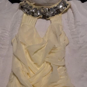 Klänning storlek xs  - Gul klänning med en krage som har diamanter på sig, knappt använd, kan skicka fler bilder vid intresse 