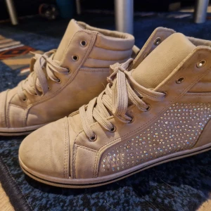 Strl 38 sneakers nude  - strl 38 bra skick, fin nude färg och vackra glänsande strass.  .     vissa skor behöver rengöras, de låg i en påse med andra skor, så de kan vara smutsiga eller dammiga, mycket bra skick, perfekt skick eller nya skor, storlek 37 eller 37,5 och alla skor p