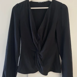 TOPP - Festtopp från Nelly, går in i midjan vilket ger är vacker passform. Vringad. Svart. Passar en S