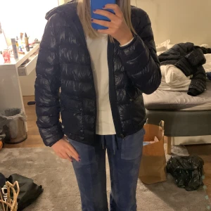 Polo jacka  - En mörkblå glansig jacka köpt förr förra året och använd rätt mycket en knapp har lossnat så man kan inte stänga en av fickorna storleken är lite otydlig men passar 11/12 år skulle jag säga 