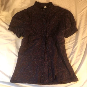Söt blus - Så söt blus som jag tyvärr växt ur..! Helt i nyskick, bara en fläck som for bort i tvätten! Så fina detaljer som ger en vintage vibe!! Färgen är typ mörk blå, lila och röd inte svart