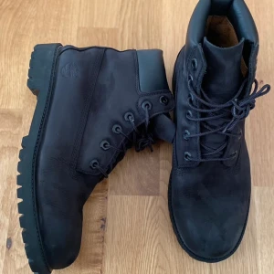 Svarta Timberlandkängor, juniorstorlek 40 - Timberland kängor i svart nubuck, waterproof. Som nya, använda ett fåtal gånger. Storlek 40. Kommer i originalkartong. 