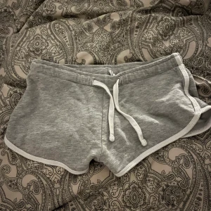 Snygga korta shorts - Säljer mina sköna gråa shorts med vita ränder som blivit försmå. Från newyorker i stl XS. Inga hål eller skador finns.