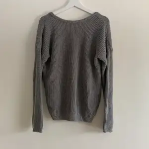 Grå stickad tröja från NA-KD. Man kan ha tröjan på båda hållen för att få en djup rygg, eller då lite mer v-ringad. Skriv för fler bilder