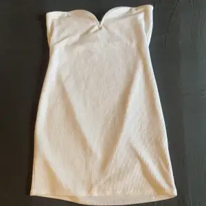 En skitsnygg vit kortklänning perfekt för utekvällar. Snygg v-ringning vid bröstet. Helt oanvänd! (Slimfit)