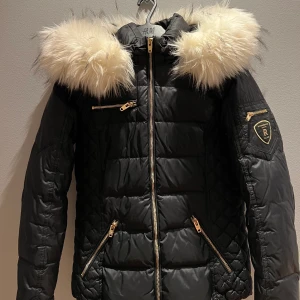 Rock and blue vinterjacka - Säljer min Rock and blue som är köpt förra sesången för 2690kr på jackan.com. Jackan har vit fluffig fake päls och är i mycket bra skick, då den är endast har används ett par gånger. Den är i storlek 34 och är figursydd men passar alla kroppstyper. 