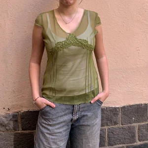 Grön mesh top - En supersöt kortärmad mesh top i grönt. Mönster där fram i form av söm och små pärlor. Perfekt till sommaren! 