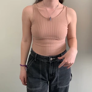 Rosa body, strl 34 - Helt oanvänd, mycket bra skick, stretchigt material och går att knyta ryggen så bra passform, öppen rygg, kan användas utan bh då det är bra support, ej genomskinlig, säljer då det var en present som inte föll mig i smaken. 